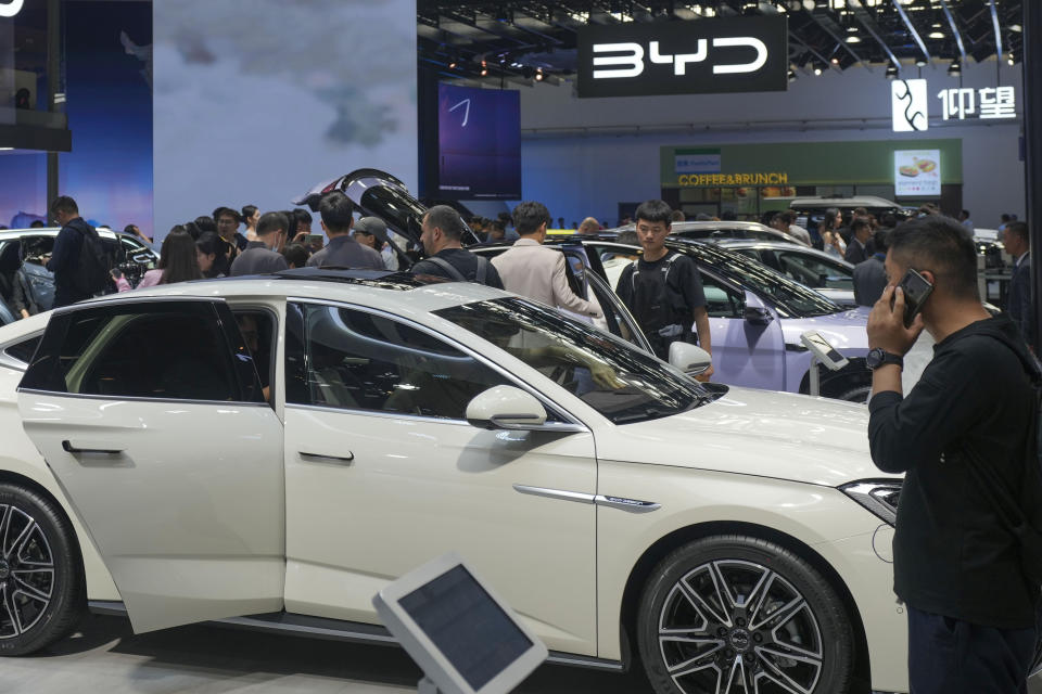 ARCHIVO - Visitantes observan autos en la exposición de BYD durante la Feria del Automóvil de China, en Beijing, China, el viernes 26 de abril de 2024. (AP Foto/Tatan Syuflana, archivo)