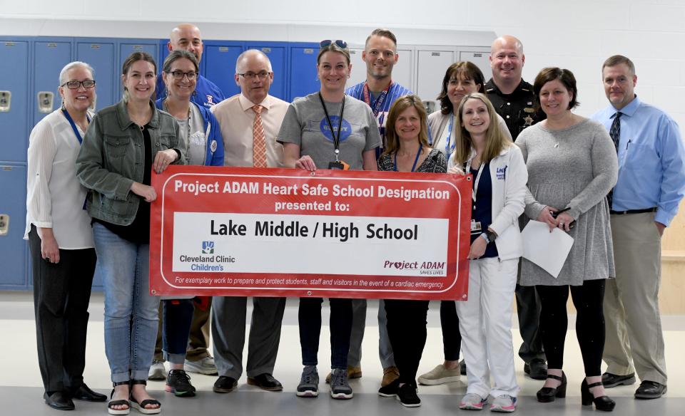 Members of Lake Middle/High School's cardiac arrest response team hold up a banner that recognizes the school as a Project ADAM Heart Safe School. Lake Local Schools is seeking to become the first Stark County school district to have all of its schools designated as heart safe schools through Project ADAM.