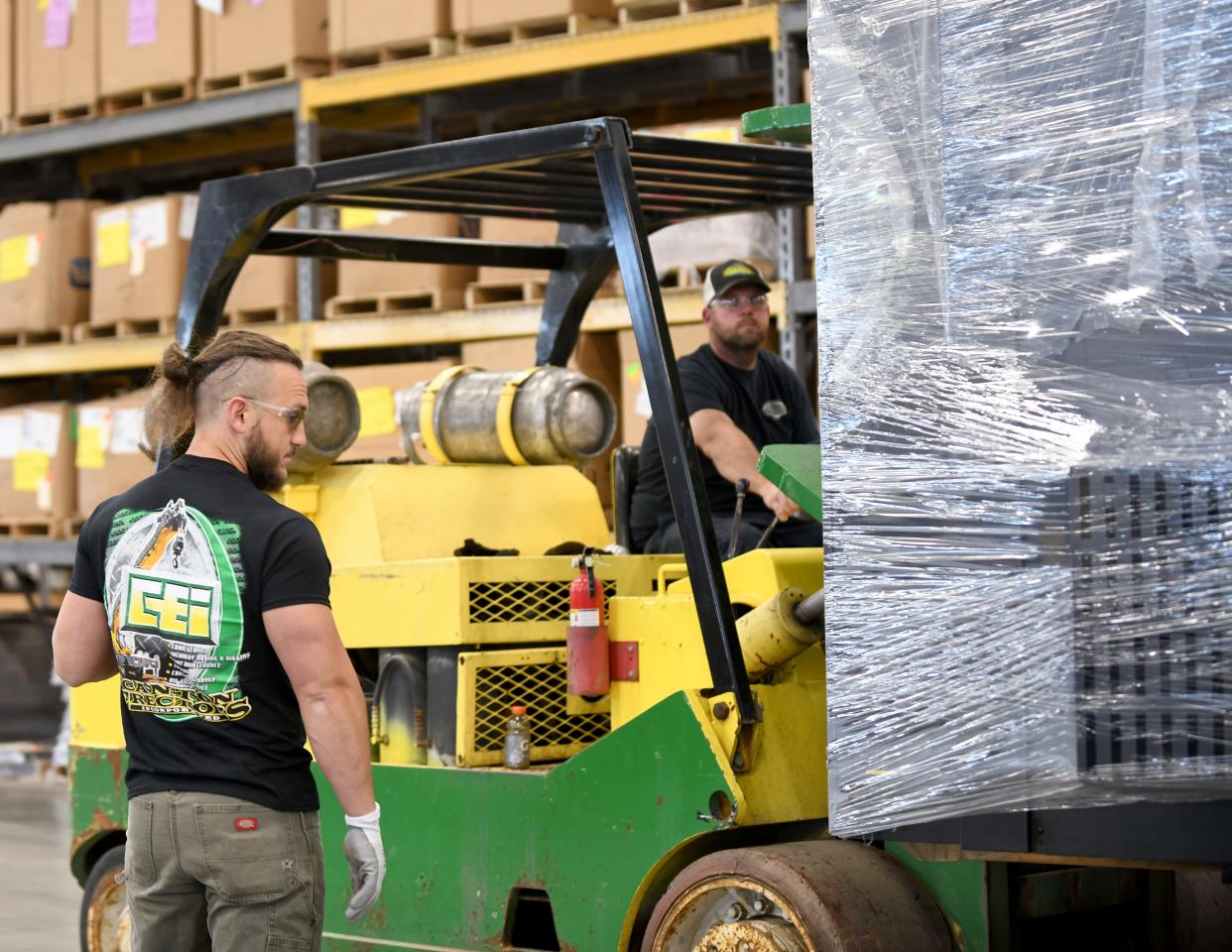 Pete Lorey, left, and Chris Smith with Canton Erectors move and place a new piece of equipment at Seco Machine in Green. Canton Erectors is one of seven companies receiving the Business Excellence Award on Thursday from the Canton Regional Chamber of Commerce.