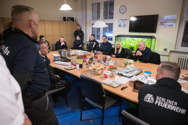 Kai Wegner (2nd R), Governing Mayor of Berlin, and Iris Spranger (3rd R), Berlin Senator for the Interior and Sport, talk to firefighters at Fire Station 2500 in the Wedding district during the New Year's Eve. Sebastian Christoph Gollnow/dpa