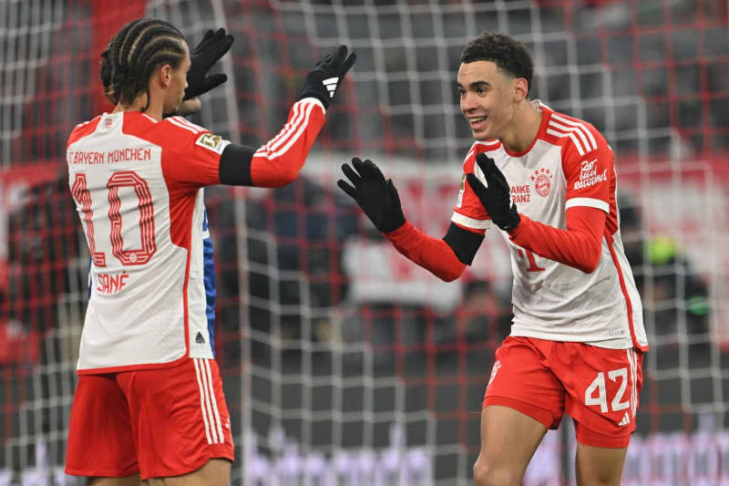 Bayern Munich's goalscorer Jamal Musiala (R) celebrates with Leroy Sane after scoring his side's second goal of the game during the German Bundesliga soccer match between Bayern Munich and TSG 1899 Hoffenheim at the Allianz Arena. Peter Kneffel/dpa