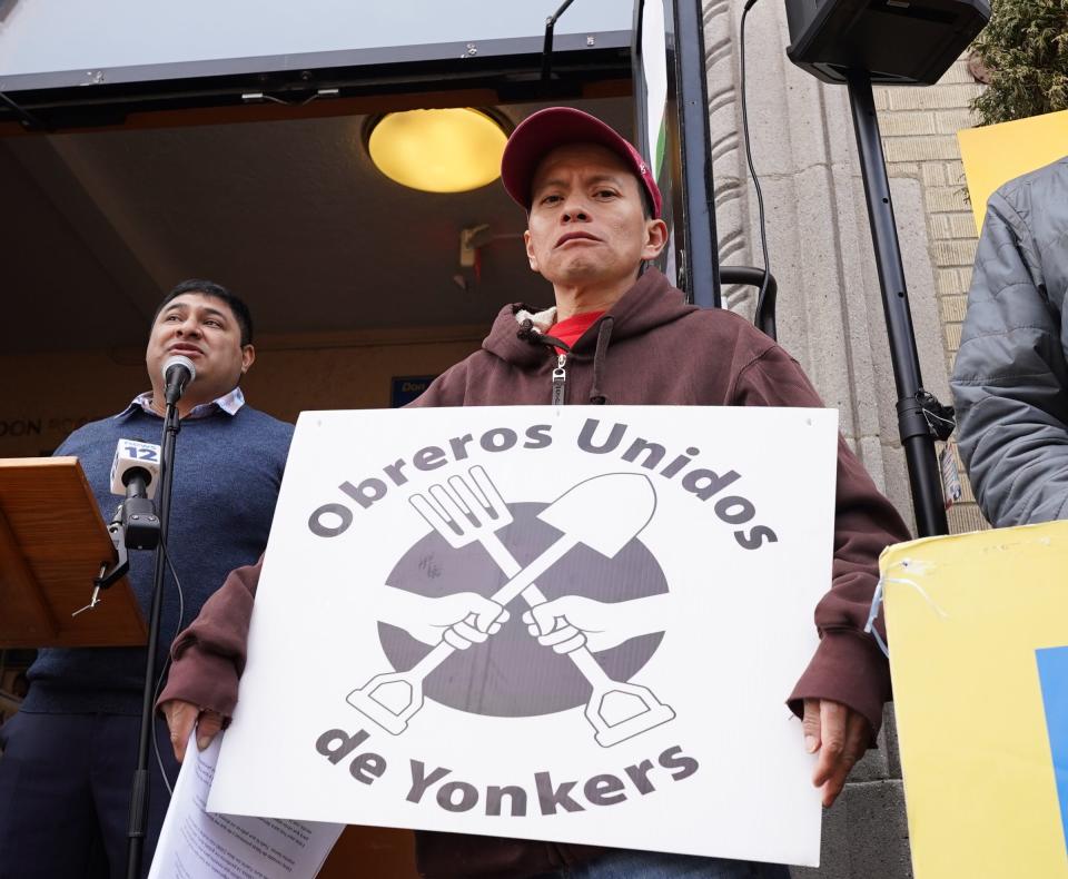 Day laborer Guadencio Encarnacion Santiago stands with a sign at a rally for wage theft in Port Chester, on Wednesday, March 22, 2023.