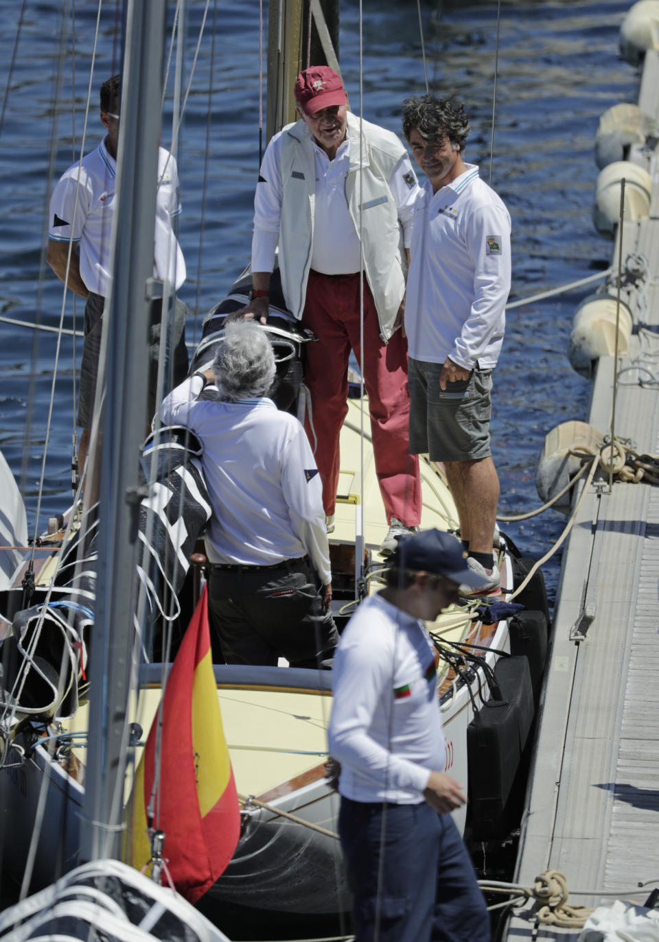 Spain's former King Juan Carlos, top center, speaks with crew members aboard the Bribon yacht before a 'regatta' race between yachts in Sanxenxo, north western Spain, Friday, May 20, 2022. Spain's former King has returned to Spain for his first visit since leaving nearly two years ago amid a cloud of financial scandals. (AP Photo/Lalo R. Villar)