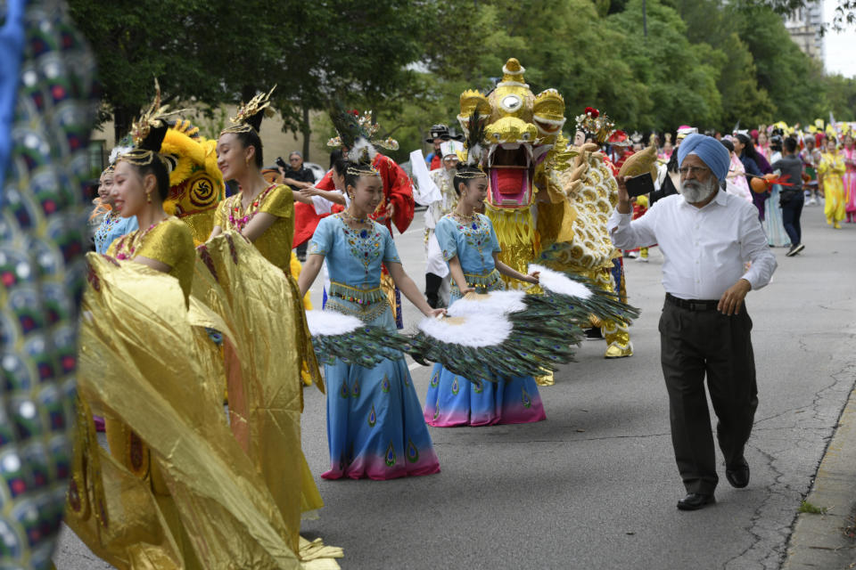 Members of the Tai Ji Men Qigong Academy perform during the Parliament of World Religion Parade of Faiths, Sunday, Aug. 13, 2023, in Chicago. (AP Photo/Paul Beaty)