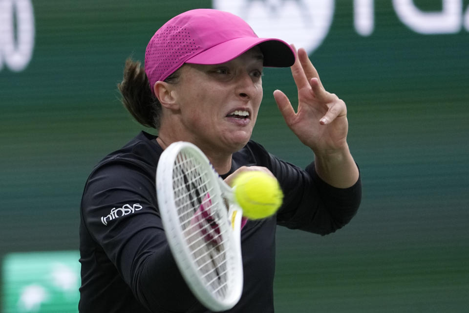 Iga Swiatek, of Poland, returns to Marta Kostyuk, of Ukraine, during a semifinal match at the BNP Paribas Open tennis tournament, Friday, March 15, 2024, in Indian Wells, Calif. (AP Photo/Mark J. Terrill)