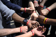 Job seekers show their wristbands, signifying which spot they are in line, as they wait in front of the training offices of Local Union 46, the union representing metallic lathers and reinforcing ironworkers, in the Queens borough of New York, April 29, 2012. About 500 people have been camping in front of the offices for a week after the State Department of Labor and the union announced they were looking to hire iron and wood apprentices for 50 positions. On Monday the first 500 people, who were given wristbands, will be given applications for the 50 positions. REUTERS/Keith Bedford (UNITED STATES - Tags: BUSINESS EMPLOYMENT)