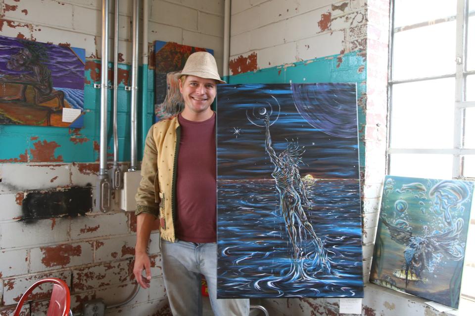 Jamin Ellison, a local artist, with one of his recent pieces at Fort Smith Coffee Co. in November. Ellison decided to pursue art as a career after years of it being a hobby and selling pieces at music festivals.