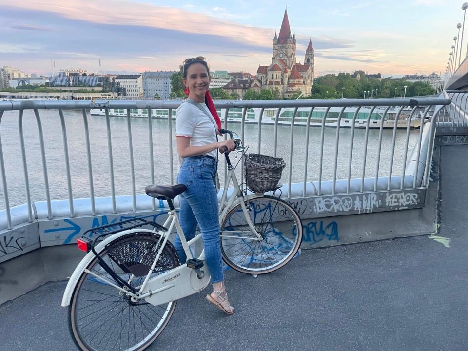 Author Sonya Matejko on a bike in front of a body of water in Vienna