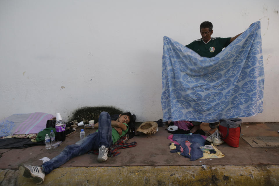 A Central American migrant traveling with a caravan to the U.S., folds his blanket after waking up, in Huixtla, Mexico, Tuesday, Oct. 23, 2018. The caravan, estimated to include more than 7,000 people, had advanced but still faced more than 1,000 miles, and likely much further, to the end of the journey. (AP Photo/Moises Castillo)