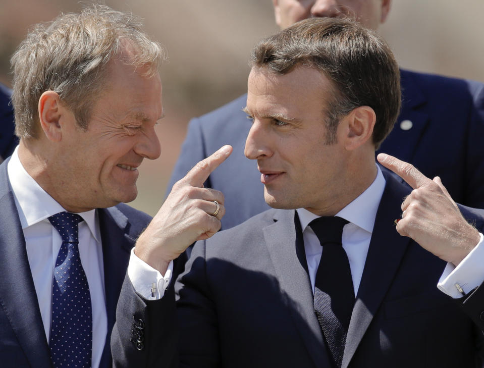 European Council President Donald Tusk, left, speaks with French President Emmanuel Macron during a group photo of EU leaders at an EU summit in Sibiu, Romania, Thursday, May 9, 2019. European Union leaders on Thursday start to set out a course for increased political cooperation in the wake of the impending departure of the United Kingdom from the bloc. (AP Photo/Vadim Ghirda)