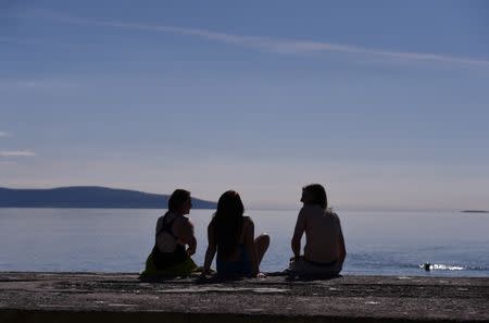 FILE PHOTO: People enjoy the sunshine at Salthill beach in Galway, Ireland April 19, 2016. REUTERS/Clodagh Kilcoyne/File Photo