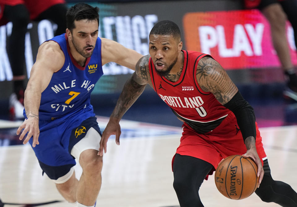 Portland Trail Blazers guard Damian Lillard (0) drives past Denver Nuggets guard Facundo Campazzo (7) in the second half of Game 1 of a first-round NBA basketball playoff series Saturday, May 22, 2021, in Denver. (AP Photo/Jack Dempsey)