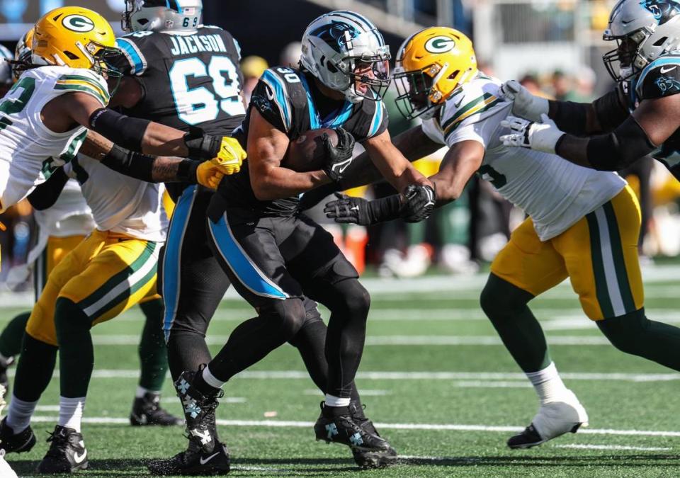 Carolina Panthers running back Chuba Hubbard (30) escapes the grasp of Green Bay Packers linebacker Rashan Gary (52) as he runs the ball during the game at Bank of America Stadium on Sunday, December 24, 2023.
