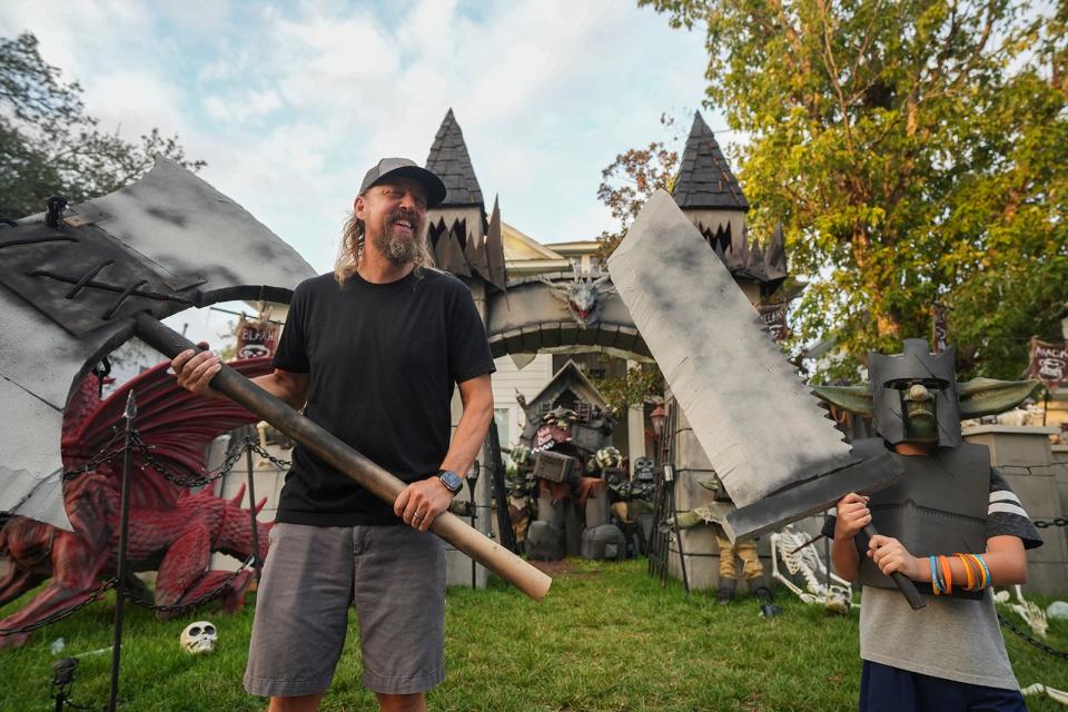 Bud Hasert stands with his son, Henry Hasert, 10, outside their home in southwest Austin on Tuesday, Oct. 24, 2023. Since 2020 Bud has elaborately decorated the family's front yard for Halloween. This year's theme is Dungeons and Dragons.
