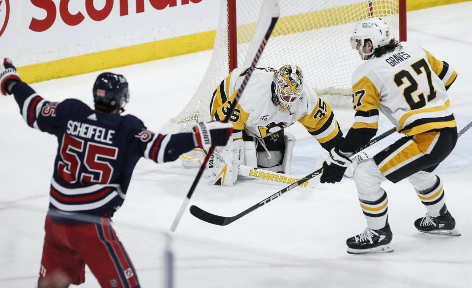 Winnipeg Jets' Mark Scheifele (55) celebrates his goal against Pittsburgh Penguins goaltender Tristan Jarry (35) during the first period of an NHL hockey game Saturday, Feb. 10, 2024, in Winnipeg, Manitoba. (John Woods/The Canadian Press via AP)