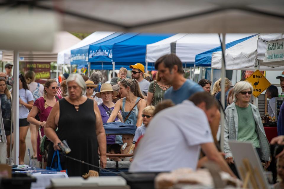 Community members browse the booths at the Larimer County Farmers' Market in Fort Collins on June 18, 2022.