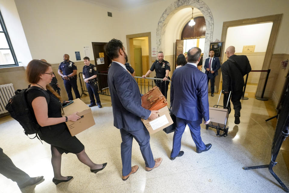 Prosecutors make their way into the courtroom for the continuation of the civil business fraud trial against former President Donald Trump at New York Supreme Court, Tuesday, Oct. 3, 2023, in New York. (AP Photo/Mary Altaffer)