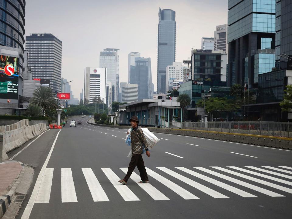 A man crosses a usually traffic-filled Sudirman Street in the main business district in Jakarta, Indonesia, on April 10.