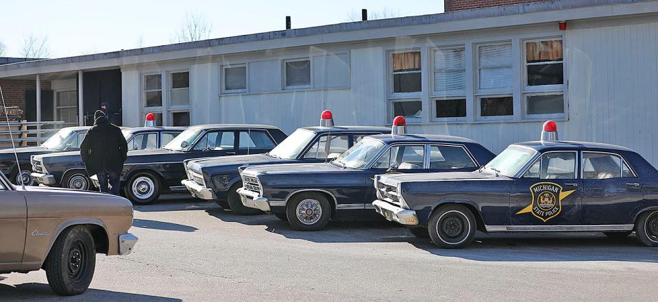 1960s-era vehicles are parked at the closed Foster School in Braintree for filming of "Boston Strangler" on Thursday, Jan. 27, 2022.