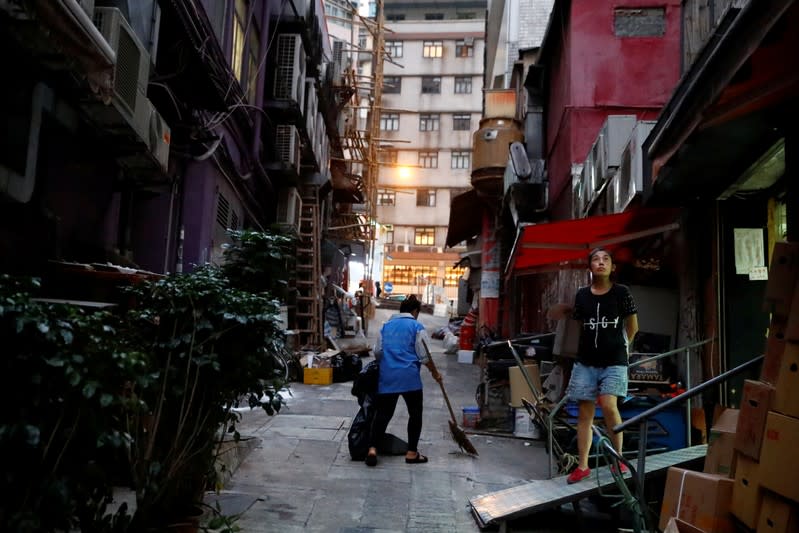 FILE PHOTO: Woman stands outside a shop in an alley in Sheung Wan in Hong Kong