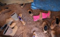 Muddy boots of children are seen in a tent in Azaz