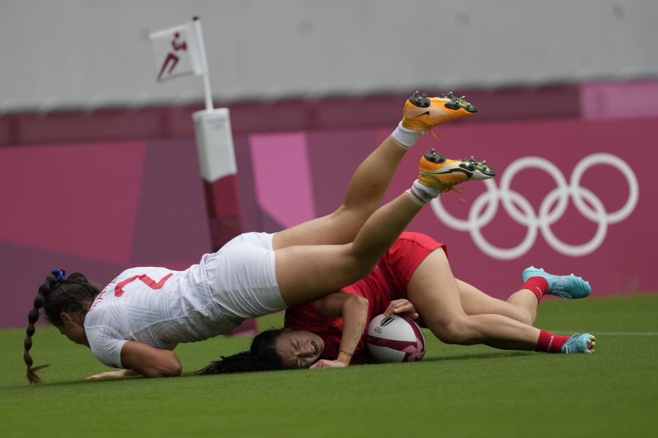 China's Chen Keyi, bottom, collides with Ilona Maher of the United States as Chen scores a try in their women's rugby sevens 5-8 placing match at the 2020 Summer Olympics, Saturday, July 31, 2021 in Tokyo, Japan. (AP Photo/Shuji Kajiyama)