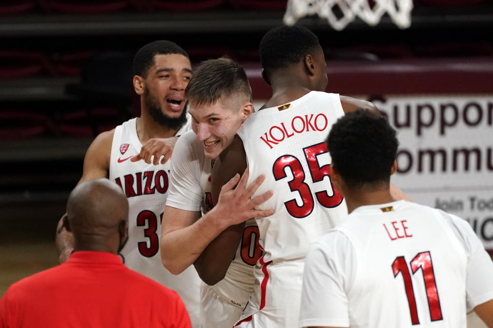 Arizona forward Azuolas Tubelis (10) celebrates with teammates after tipping in a basket a the buzzer during the team's NCAA college basketball game against Arizona State, Thursday, Jan. 21, 2021, in Tempe, Ariz. Arizona won 84-82. (AP Photo/Rick Scuteri)