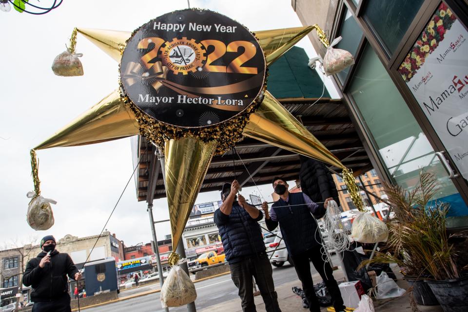The City of Passaic prepares for the New Year's Eve piñata drop on Friday, Dec. 31, 2021. (From left) Passaic Deputy Chief Louis Gentile, DPW Supervisor Robert Urena and Javier Clara, an owner of 3Reyes Dulcelandia candy shop and piñata maker. 