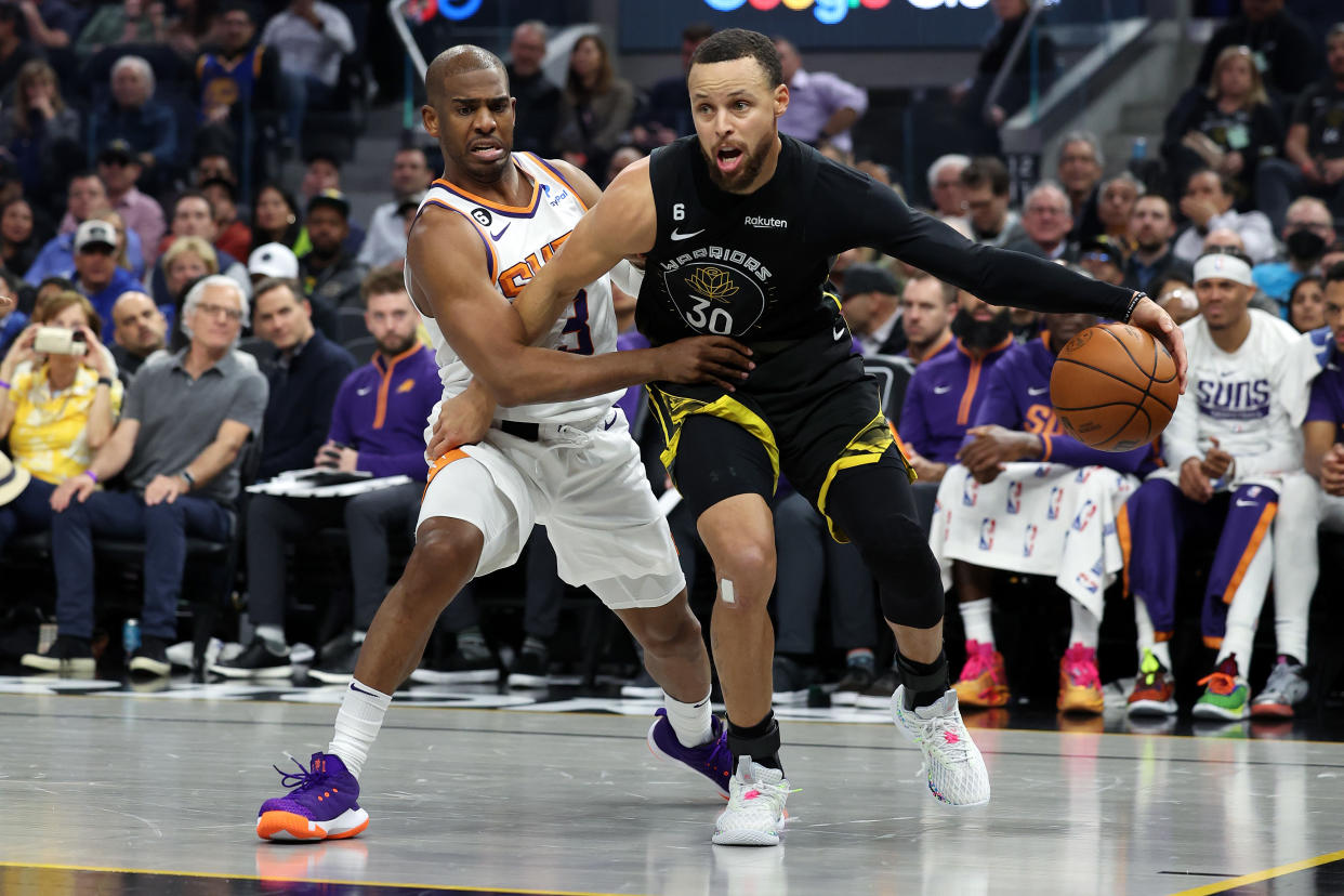 Golden State's Stephen Curry is defended by then-Phoenix guard Chris Paul during a game in March. Now, the two will be Warriors teammates. (Ezra Shaw/Getty Images)