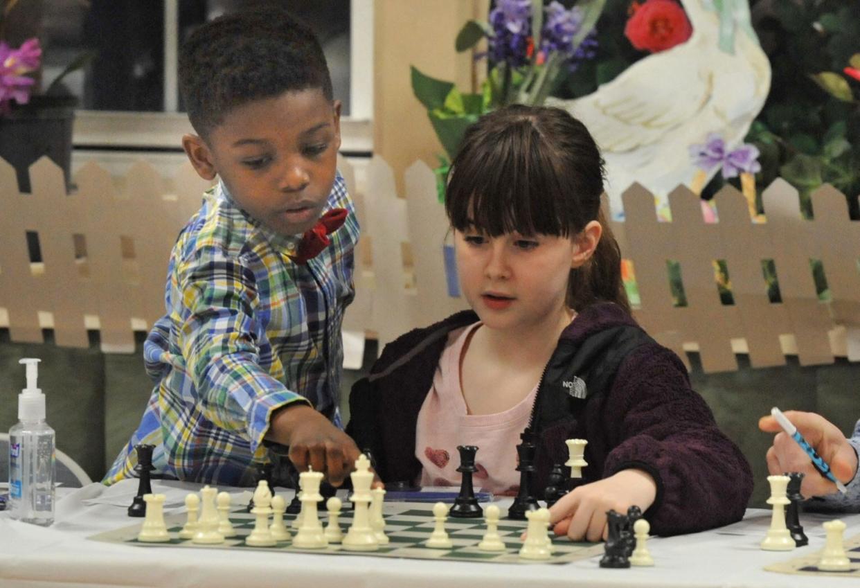 Miles Black, 7, of Holbrook, left, helps Maddy Goodman, 9, of Weymouth, right, with some strategy during a chess competition with Grandmaster Nadya Kosintseva at the South Shore Chess Club in Quincy on Wednesday, March 28, 2024.