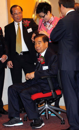 Chow Tai Fook Jewellery Group honorary chairman Cheng Yu-tung sits on a chair during the trading debut of the company at the Hong Kong Stock Exchange, China December 15, 2011. REUTERS/Tyrone Siu/File photo