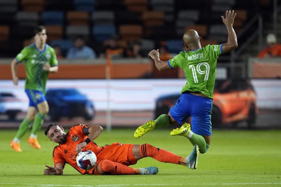 Houston Dynamo's Héctor Herrera, left, takes the ball away from Seattle Sounders' Héber (19) during the second half of an MLS soccer match Saturday, May 13, 2023, in Houston. (AP Photo/David J. Phillip)