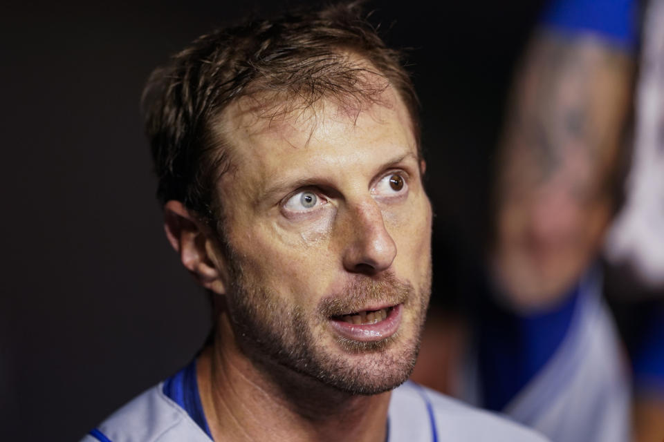 New York Mets starting pitcher Max Scherzer walks in the dugout during the third inning of a baseball game against the Washington Nationals at Nationals Park, Friday, April 8, 2022, in Washington. (AP Photo/Alex Brandon)