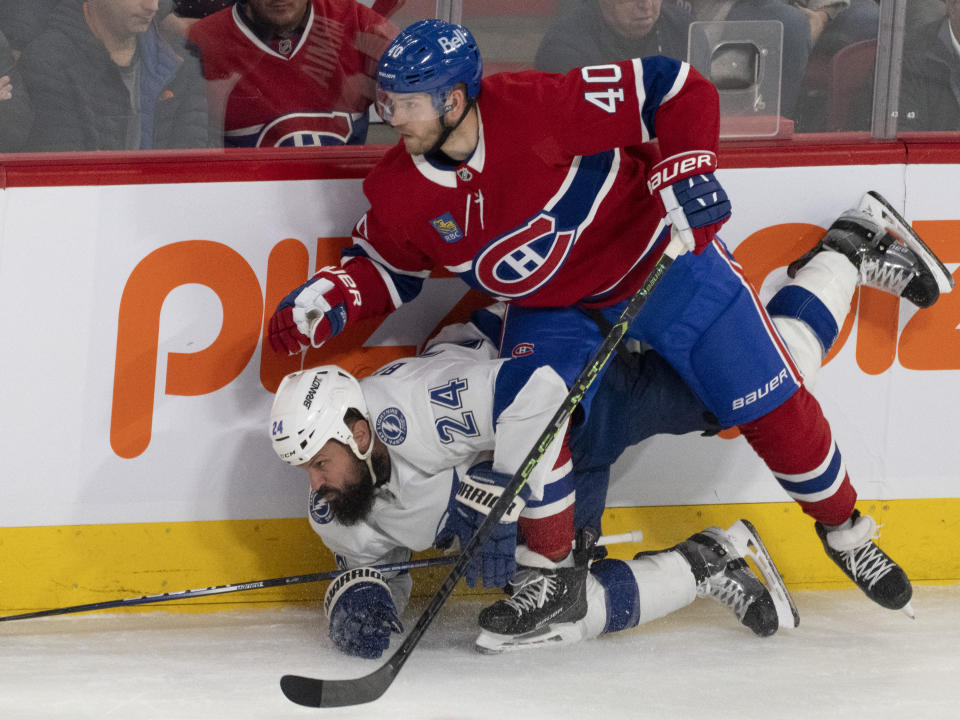 Tampa Bay Lightning's Zach Bogosian (24) is checked into the boards by Montreal Canadiens' Joel Armia (40) during the second period of an NHL hockey game, Tuesday, Nov. 7, 2023 in Montreal. (Christinne Muschi/The Canadian Press)