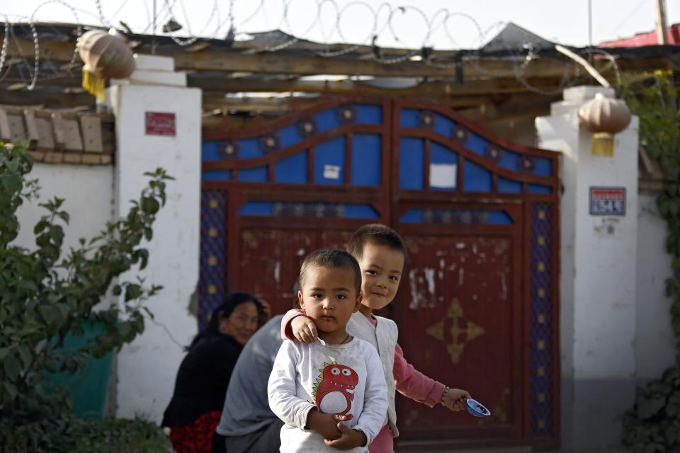 Niños uighur juegan con sus familiares en China  (AP Photo/Andy Wong).