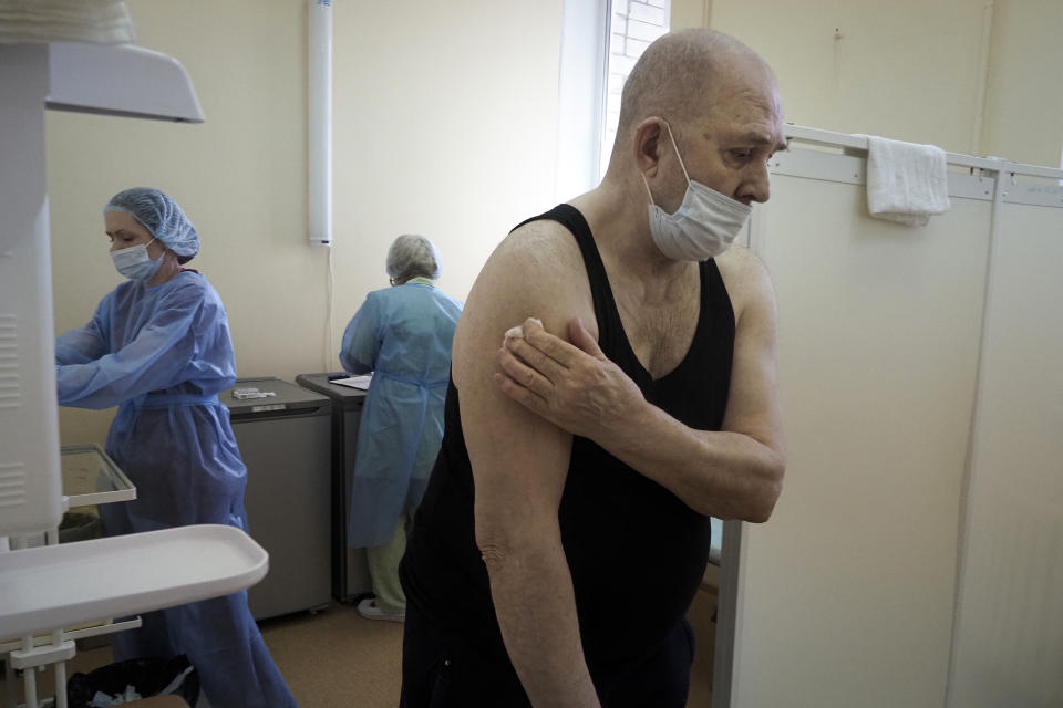 An elderly man leaves a room after getting a shot of Russia's Sputnik V coronavirus vaccine in the clinic in Petrozavodsk, Karelia region, Russia, Monday, Feb. 15, 2021. Russia took pride in being the first country to approve a coronavirus vaccine, although it faced criticism from aboard for doing it before completing the advanced testing necessary to ensure Sputnik V’s safety and effectiveness. (AP Photo/Dmitri Lovetsky)
