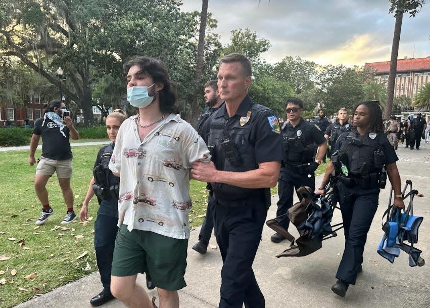 A protester is detained by police on Monday, April 29, 2024 on the campus of the University of Florida.
