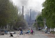 Smoke rises above a plant of Azovstal Iron and Steel Works in Mariupol