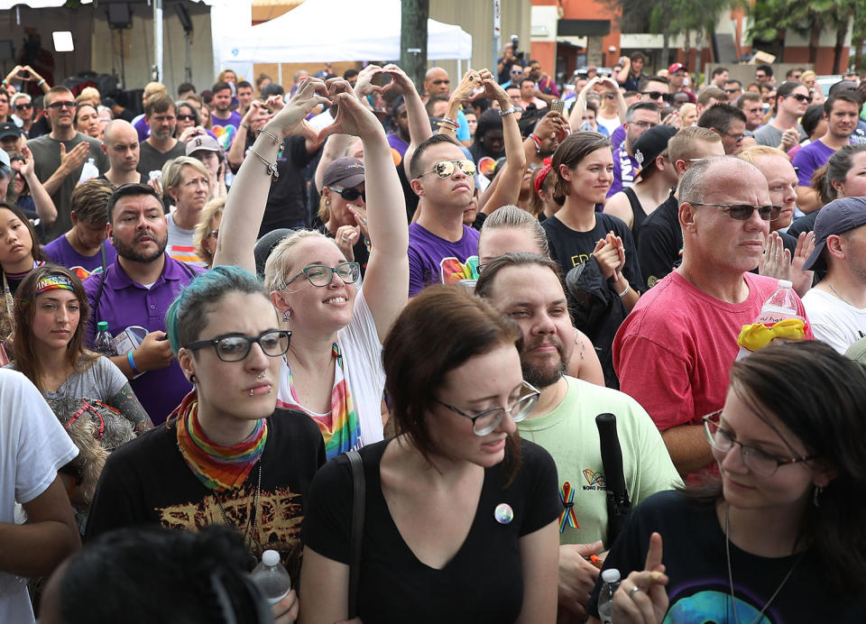 <p>People mourning the loss of family, friends and loved ones in the mass shooting at the Pulse gay nightclub gather together outside the club during a one-year anniversary memorial service on June 12, 2017 in Orlando, Florida. (Joe Raedle/Getty Images) </p>