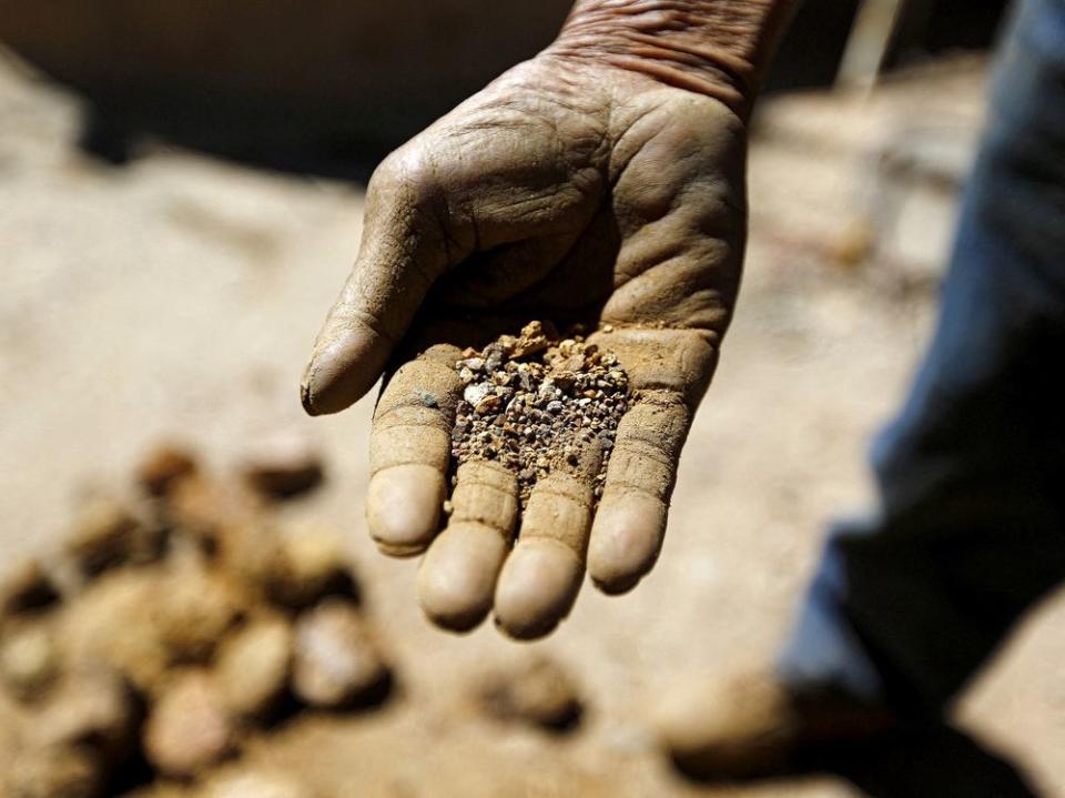 FILE PHOTO: An artisanal miner shows ore at a small copper and gold processing plant of the 