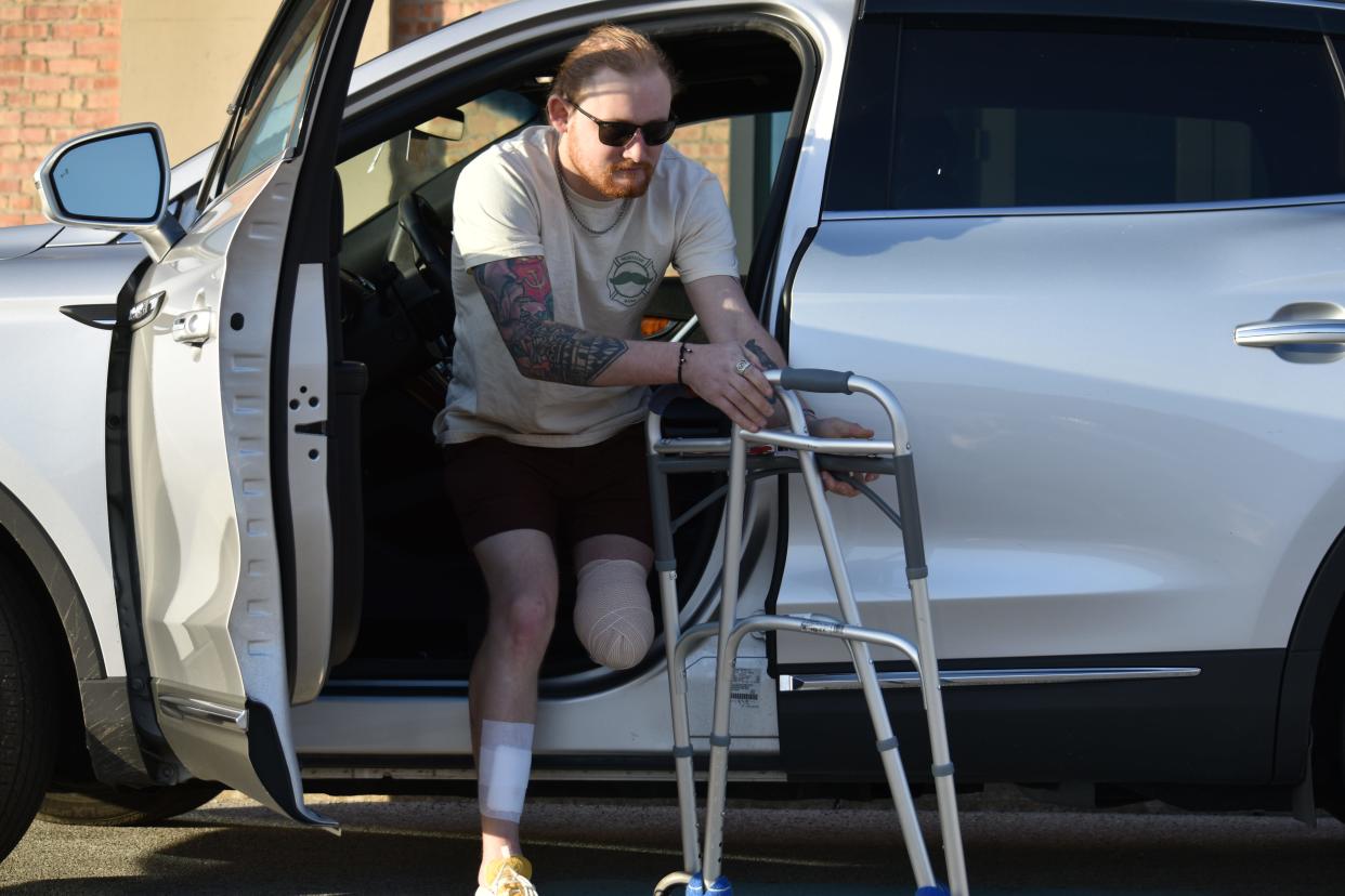 Matt Reum reaches to pull his walker into his new car on Feb. 14, 2024. Reum, a 27-year-old South Bend resident, survived six days beneath a bridge under Interstate-94 before he was found by two men in search of a good fishing hole. With his new platform, Reum hopes to assuage people's despair.