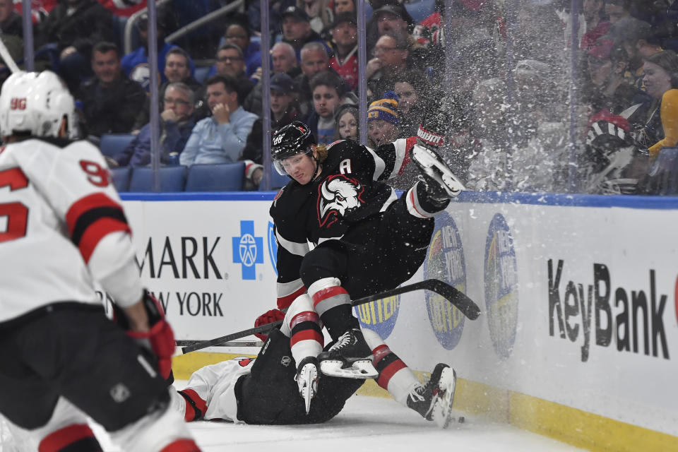 Buffalo Sabres defenseman Rasmus Dahlin (26) is upended by New Jersey Devils center Nico Hischier, bottom right, during the first period of an NHL hockey game in Buffalo, N.Y., Friday, March 24, 2023. (AP Photo/Adrian Kraus)