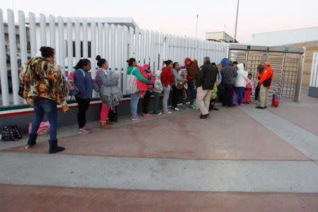 Immigrants from Central America and Mexican citizens, who are fleeing from violence and poverty, queue to cross into the U.S. to apply for asylum at the new border crossing of El Chaparral in Tijuana, Mexico, November 24, 2016. REUTERS/Jorge Duenes