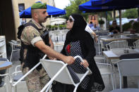 A Lebanese soldiers banned a depositor of using a coffeeshop chair to break a bank window, in Beirut, Lebanon, Friday, Sept. 24, 2021. Dozens of Lebanese depositors protested throwing eggs and tomatoes on a number of private banks in central Beirut, demanding to have access to their deposits which have been blocked under informal capital controls since the country's financial and economic crisis began in late 2019. (AP Photo/Hussein Malla)