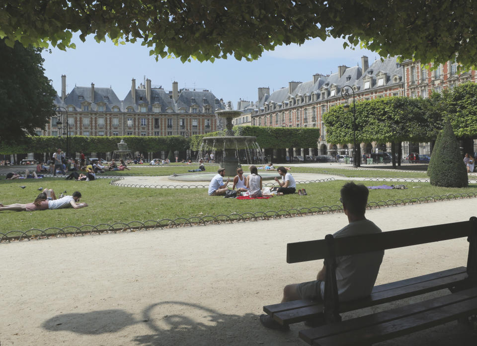 A man sits on a bench in the park at the center of the Peoples Place des Vosges, in the Maris district, in Paris, Wednesday, July 17, 2013. While the rest of Paris can feel sleepy, the Marais positively buzzes on Sundays. (AP Photo/Jacques Brinon)