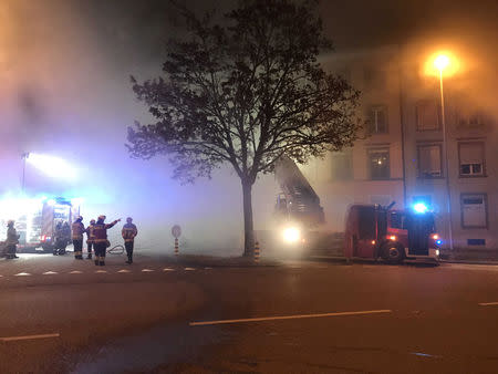 Firefighters are seen in front of a house where six people were killed in an apartment fire early on Monday morning, police said, while an unspecified number of others caught in the blaze were taken to the hospital in Solothurn, Switzerland November 26, 2018. Polizei Kanton Solothurn/Handout via REUTERS.