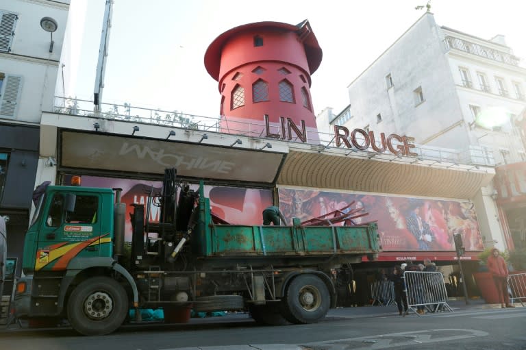 Des ouvriers sécurisent la zone devant le Moulin Rouge à Paris après que ses ailes et des lettres de la façade sont tombées dans la nuit sans faire de blessés, le 25 avril 2024 (Geoffroy VAN DER HASSELT)