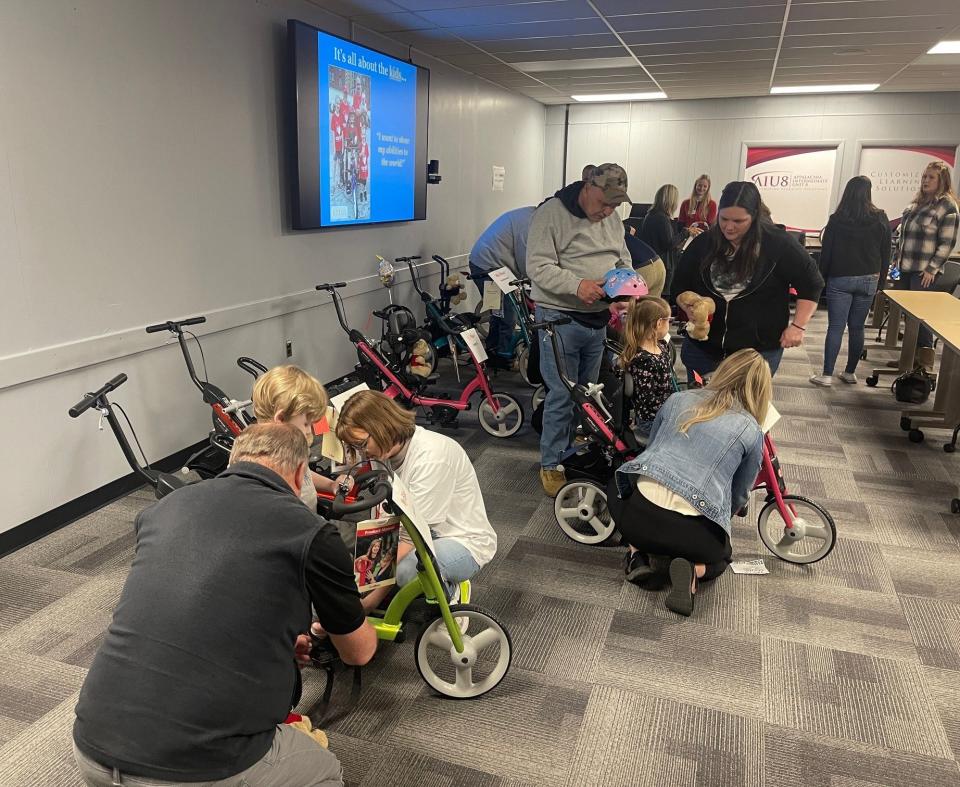 Staff from Blackburn's medical equipment and Appalachia IU8 show families how to secure their children onto their bikes at the Variety bike presentation on April 4 in Johnstown.