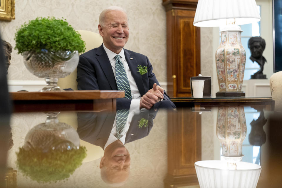 President Joe Biden sits next to a bowl of Irish shamrocks, left, as he has a virtual meeting with Ireland's Prime Minister Micheal Martin on St. Patrick's Day, in the Oval Office of the White House, Wednesday, March 17, 2021, in Washington. (AP Photo/Andrew Harnik)