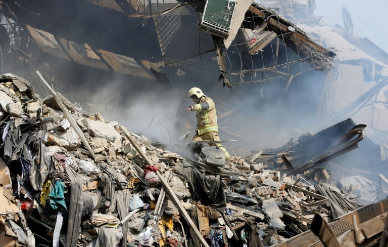 A firefighter walks through the debris of Iran's oldest high-rise, the 15-storey Plasco building in central Tehran, after it collapsed on January 19, 2017 following a fire